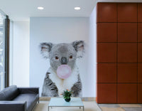 Whimsical koala with bubble gum captured in a vibrant wall mural.

