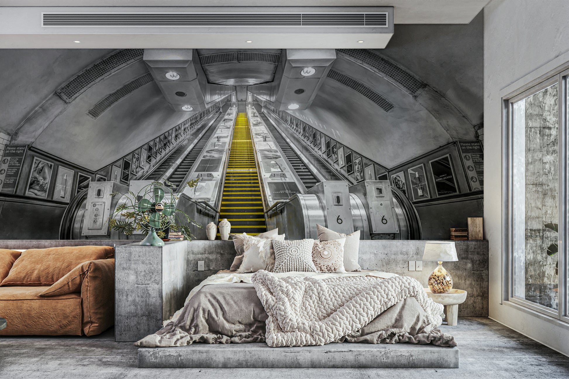 City subway escalator with yellow accents on mural wall

