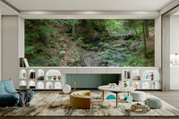 Gentle forest stream flowing through vibrant green foliage on a wall.

