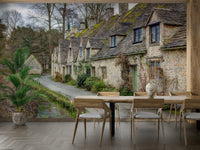 The image shows a row of historic stone cottages with moss-covered slate roofs.

