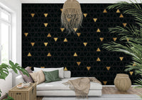 This abstract wallpaper features a pattern of interlocking black and gold triangles, creating a luxurious and modern effect.