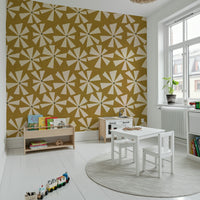 Decorative wallpaper with playful cream flower bursts set against a rich mustard tone.