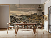 Serene mural capturing a lighthouse above rugged rocks with soft golden light on the horizon.