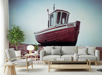 Vintage Boat Resting on Pebbled Strand wallpaper for walls, maroon hull, shingle.