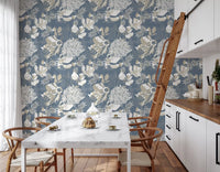 Beige palm leaves and blooms wrap the dining room in Dusty Blue wallpaper.