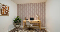 Vertical off-white lines cascade smoothly down this textured pink wallpaper.