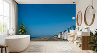 Blue sky and pastel fronts brighten a Bathroom via the Beach Hut wall mural
