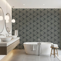 Irregular triangle outlines lend the charcoal mudcloth wallpaper a woven, tribal look