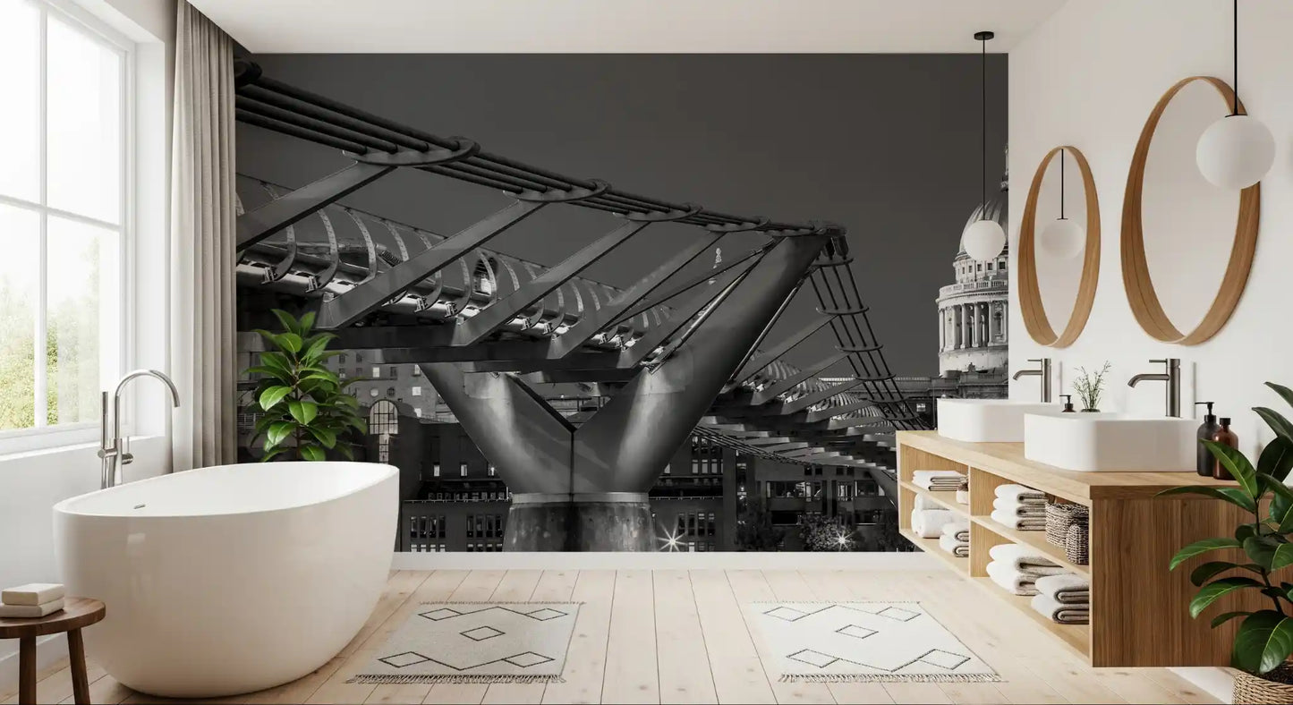 South-bank buildings stand evenly behind this Millennium Bridge wall mural at night.