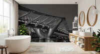 South-bank buildings stand evenly behind this Millennium Bridge wall mural at night.