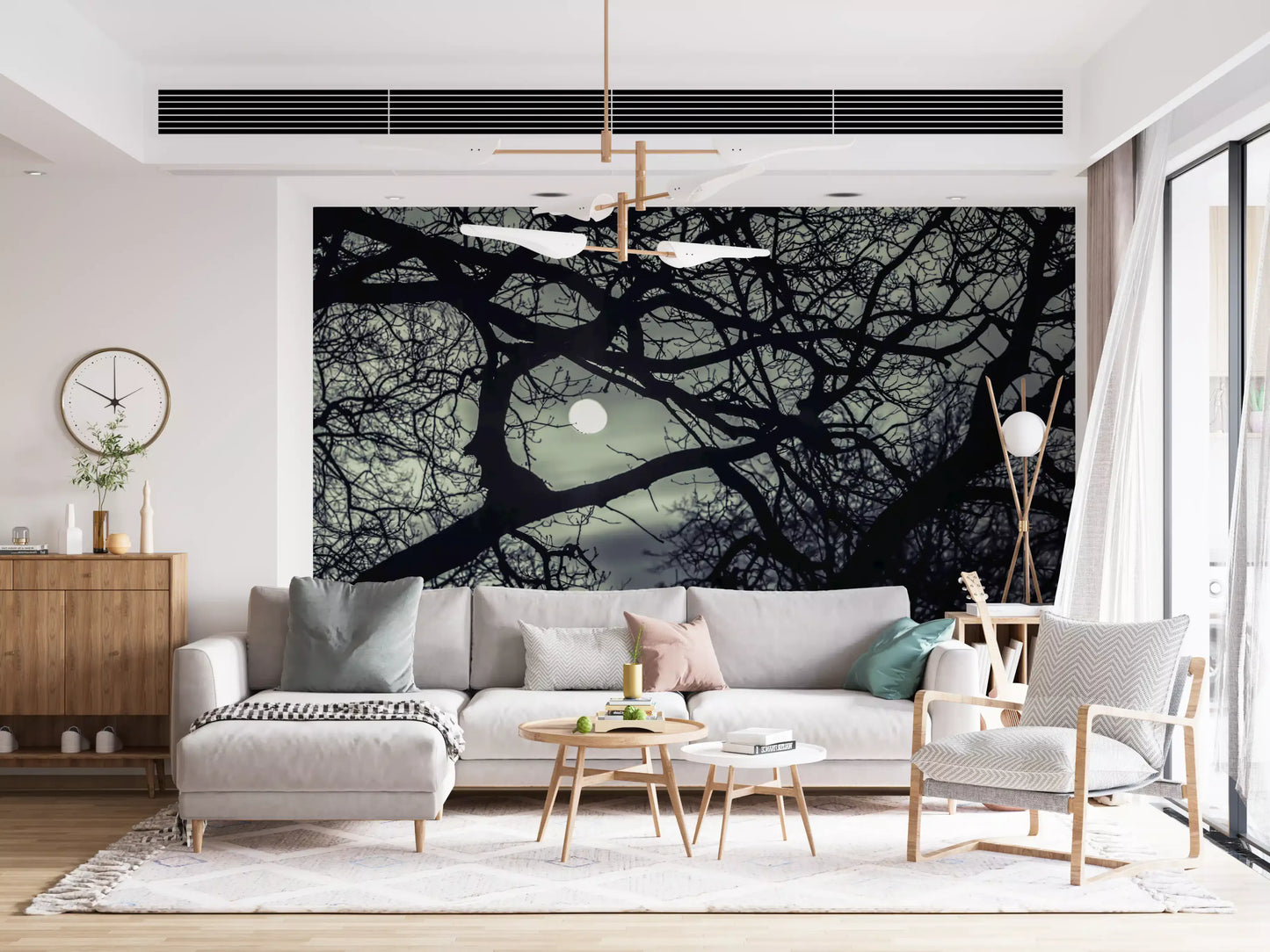 Tangled dark limbs from this Lunar Silhouette wall mural hang above a living room.