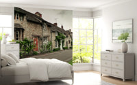 Bedroom spaces reflect the rustic timeless stone building street wall mural scene.