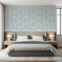 In a bedroom the Painted Coraline Dreaming Blue wallpaper sits with quiet botanical air.