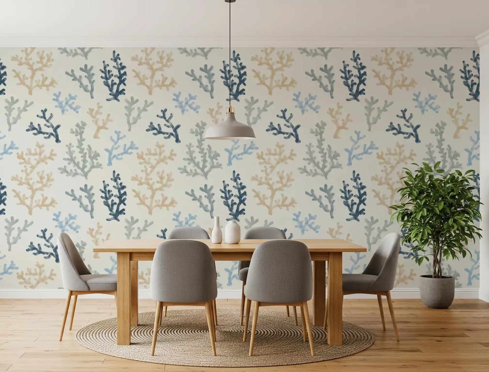 A wooden dining table sits perfectly against the Painted Corals Wallpaper backdrop.