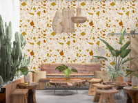 Cream terrazzo wallpaper carrying sage, peach, and ochre fragments