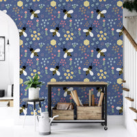 Pale blue daisy and dot clusters fill the bee and bloom wallpaper
