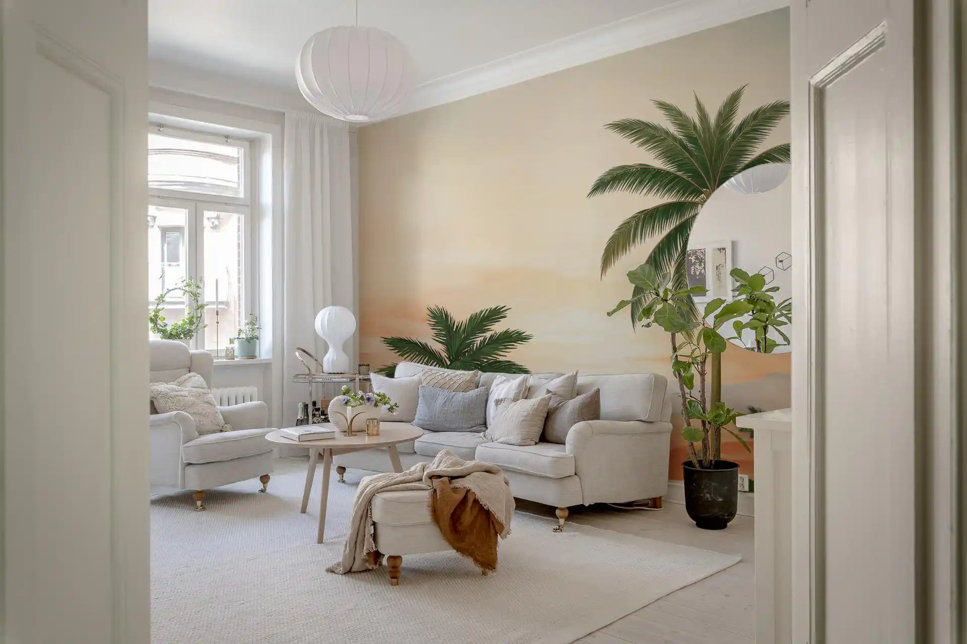 Peach skies and green palms warm a lounge under Lush Retreat wall mural.