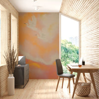 Two herons glide through the peach sky of this Soaring Dreams wall mural