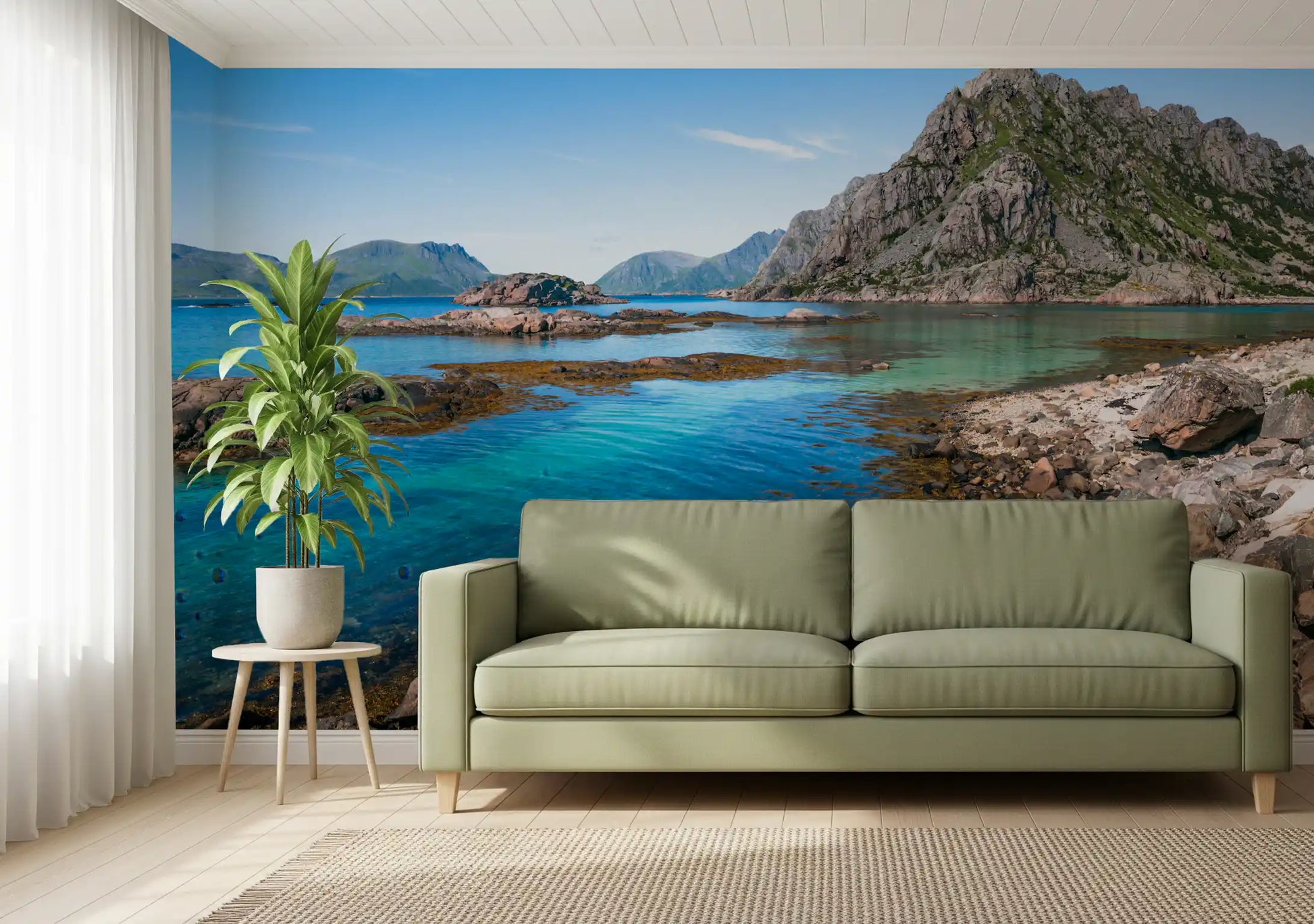 Living room set against rocky coastline and clear blue water wall mural