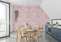 Pure white sits behind pink, coral and peach blooms on the wallpaper
