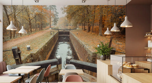 Woodland wall mural featuring golden foliage beside calm water