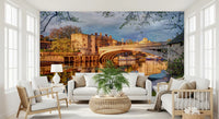 Historic town wall mural with reflections across a calm river