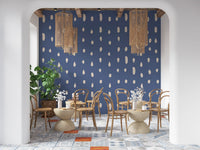 Varied droplets and ovals form a steady wall mural pattern across dusty blue.