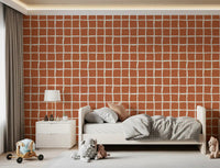 Slightly tilted squares ride a Wavy Grid Terracotta wallpaper in cream and clay.