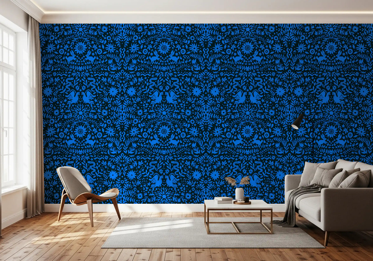 Cobalt folk art wallpaper behind a grey sofa and accent chair with a gold side table GD12263