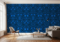 Cobalt folk art wallpaper behind a grey sofa and accent chair with a gold side table GD12263