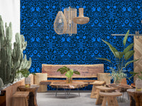 Blue folk art wall in a rustic room with cactus and live-edge wood tables GD12263