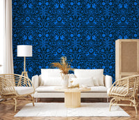 Blue folk art wall behind a white sofa with cane chairs and pampas grass GD12263
