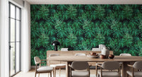 Dark green palm canopy wallpaper behind a round wooden dining table and beige chairs GD12296
