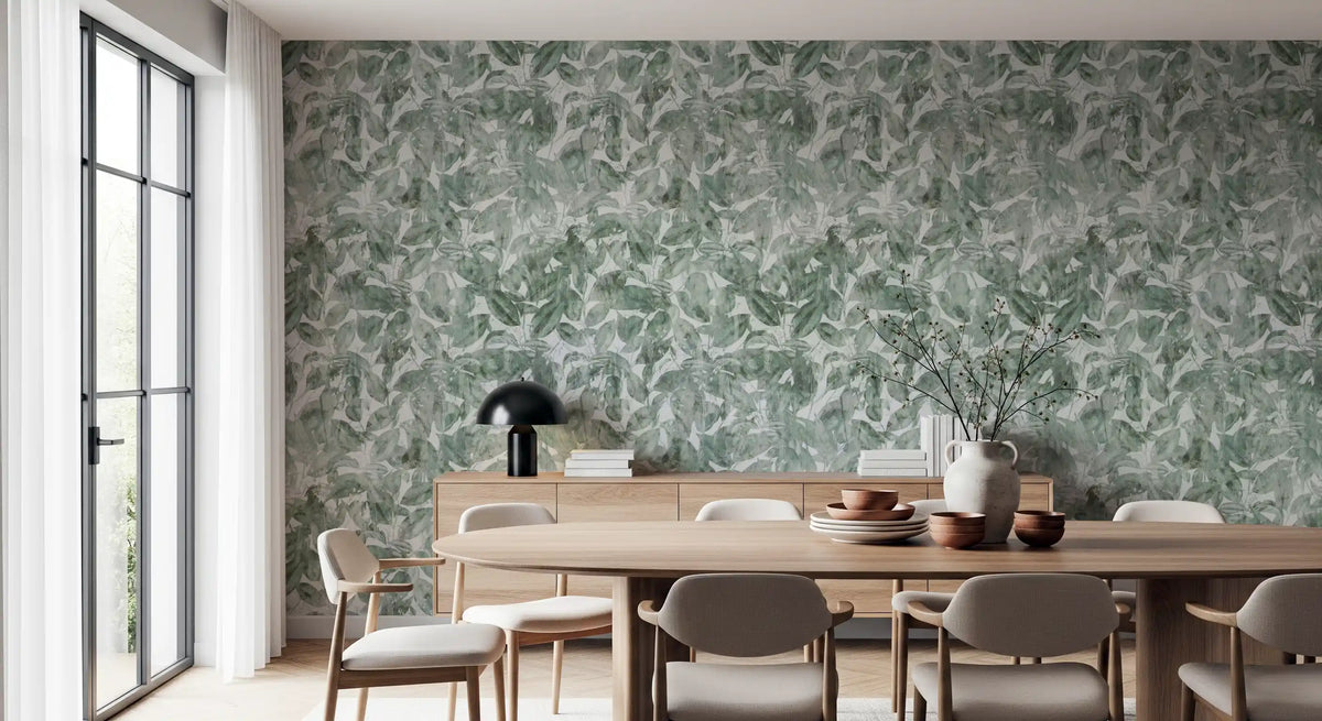 Round wooden dining table and taupe chairs against misty forest leaf wallpaper GD12325