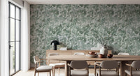 Round wooden dining table and taupe chairs against misty forest leaf wallpaper GD12325