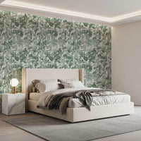 Cream upholstered bed and marble nightstand against misty forest leaf canopy wallpaper GD12325