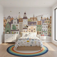 Pastel village townscape mural behind a bed with confetti dot bedding and a rainbow rug GD12398