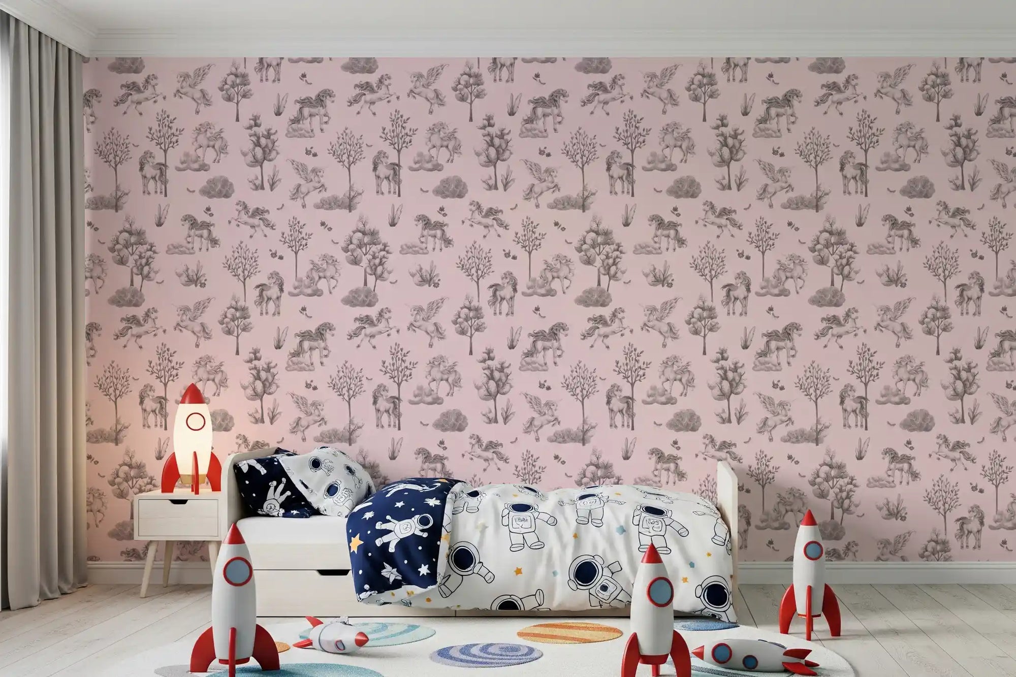 Blush unicorn wallpaper behind a kids bed with space bedding and red rocket toys GD12409