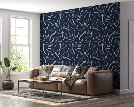 Crayon scribble arrows wallpaper behind a brown leather sofa and leafy corner plant GD12451