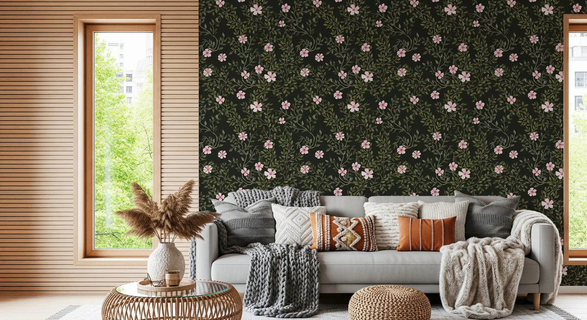 Soft pink floral wallpaper behind a grey sofa with pampas grass and a rattan table GD12467