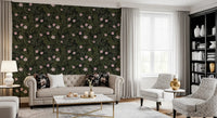 Soft pink floral wallpaper behind a tufted cream sofa with gold accents and a bookshelf GD12467