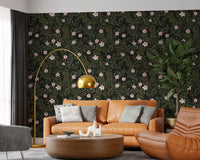 Pink floral vines on charcoal wallpaper behind a tan leather sofa and gold arc floor lamp GD12467