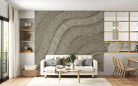 Taupe wavy etched lines mural behind a cream sofa with wooden dining chairs and shelving GD12471