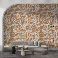 Abstract earth toned shapes wallpaper behind a grey sofa beside an arched wall GD12478