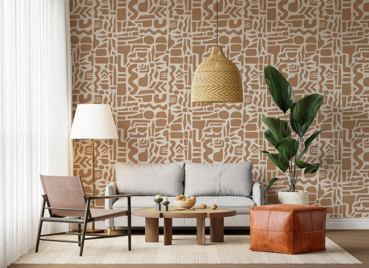 Abstract shapes wallpaper behind a grey sofa with a tan leather pouf and plant GD12478