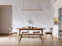 Blue wave wallpaper behind a wood dining table in a bright kitchen diner GD12498