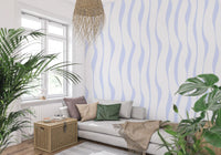 Flowing blue hues wallpaper behind a grey sofa with a monstera plant GD12498