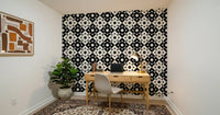 Geometric starburst wallpaper behind a wooden home office desk and chair GD12503