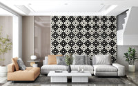 Black and white geometric motif wallpaper in a lounge with a grey sofa and tan bench GD12503