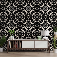 Monochrome circle grid wallpaper above a wooden console with plants and a lamp GD12506